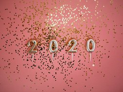 Neujahresvorsätze - Ballons 2020 mit Konfetti auf pinkem Hintergrund