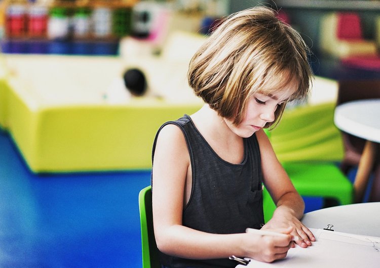 Artikel Autismus junges Mädchen an einem Tisch