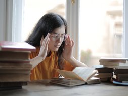 Artikel CFS Frau mit Büchern fasst sich an den Kopf
