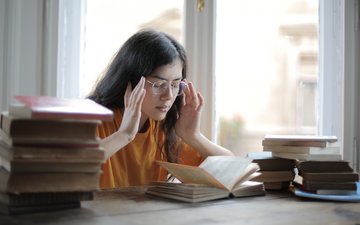 Artikel CFS Frau mit Büchern fasst sich an den Kopf