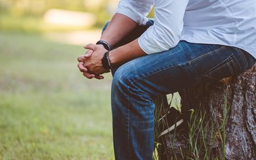 Artikel Therapiegarten Rhein-Jura: Mann sitzt auf einem Baumstamm
