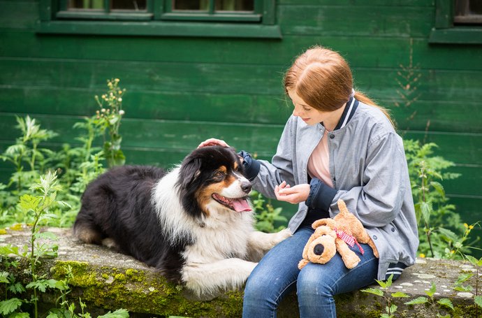 Artikel Persönlichkeitsstörungen: Frau mit Hund vor grünem Haus