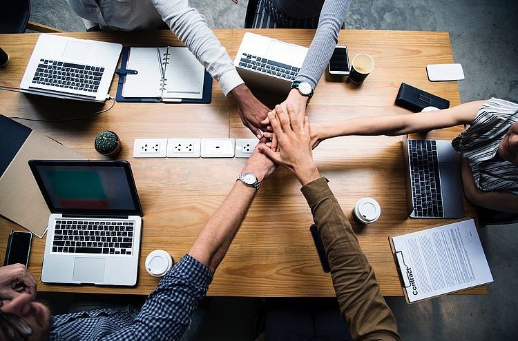 Menschen bei der Arbeit halten Hände zusammen