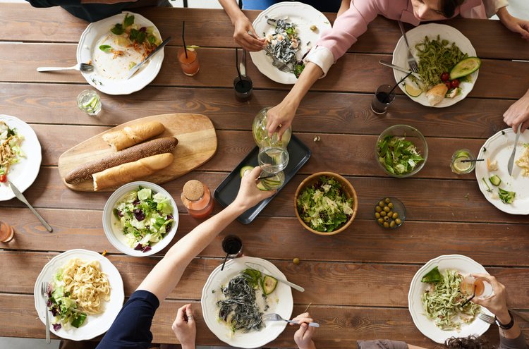 Artikel Ernährung und Depressionen: Tisch mit mehreren Gerichten und Menschen